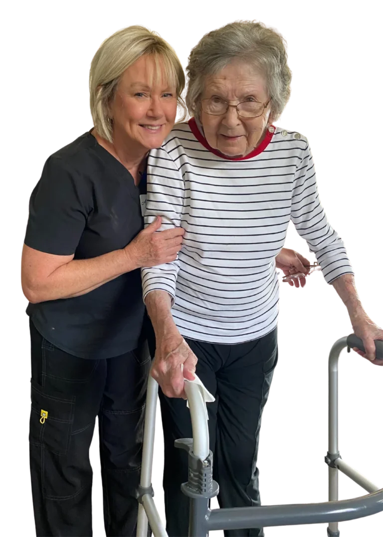 An age in place home care services client standing next to her caregiver with her walker and smiling.