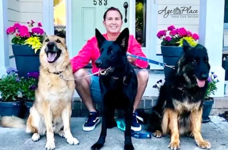 Age in Place Home Care services owner, Chris Gulley smiling and sitting with his 3 dogs