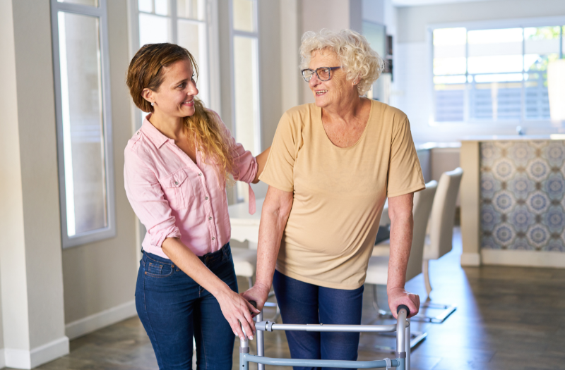 Age in place client using a walker standing next to her daughter and smiling