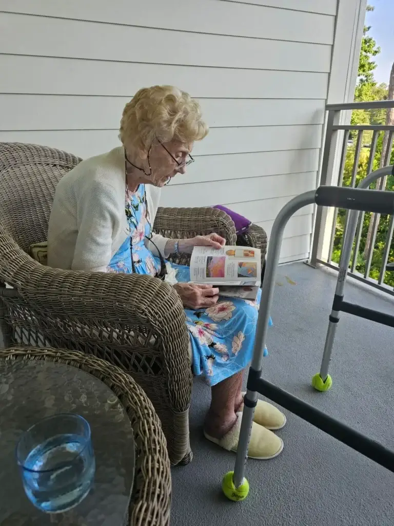 Senior woman reading on porch with walker, promoting safe aging in place in Wilmington, NC.