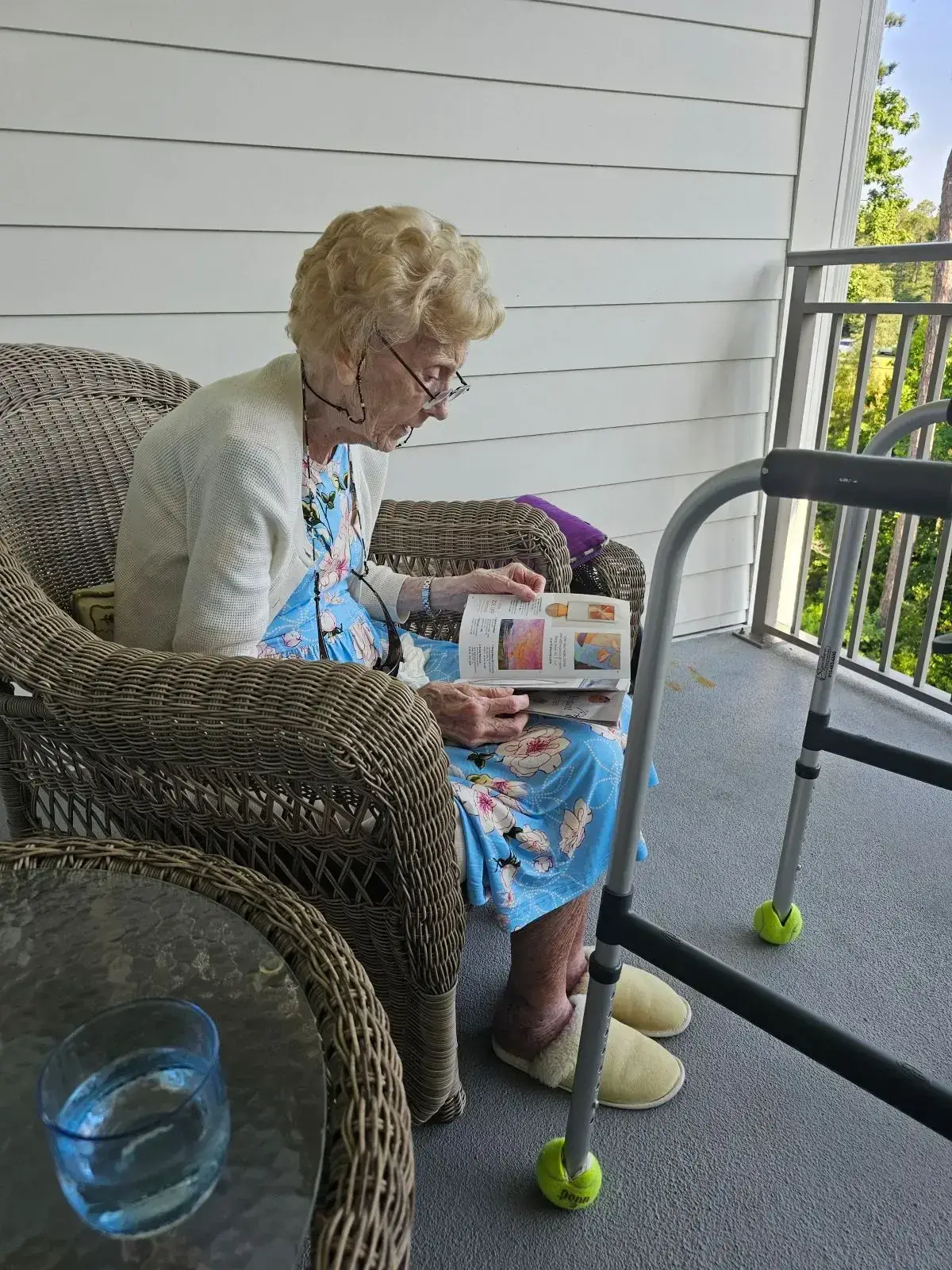 Senior woman reading on porch with walker, promoting safe aging in place in Wilmington, NC.